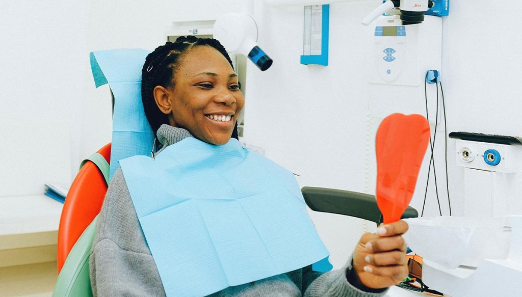 dental patient looking at handheld mirror