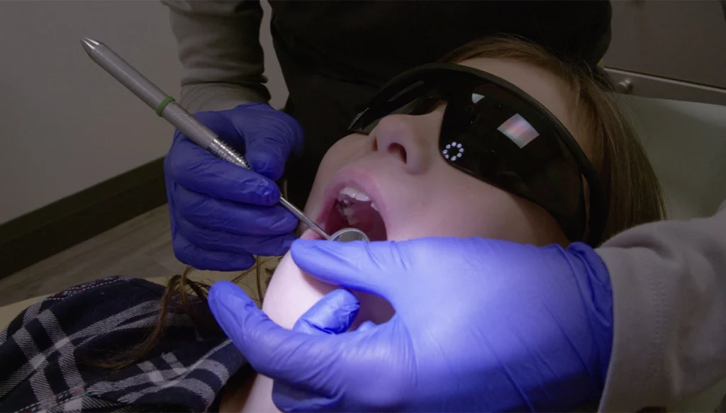 Teenager in a dentist chair getting his teeth cleaned