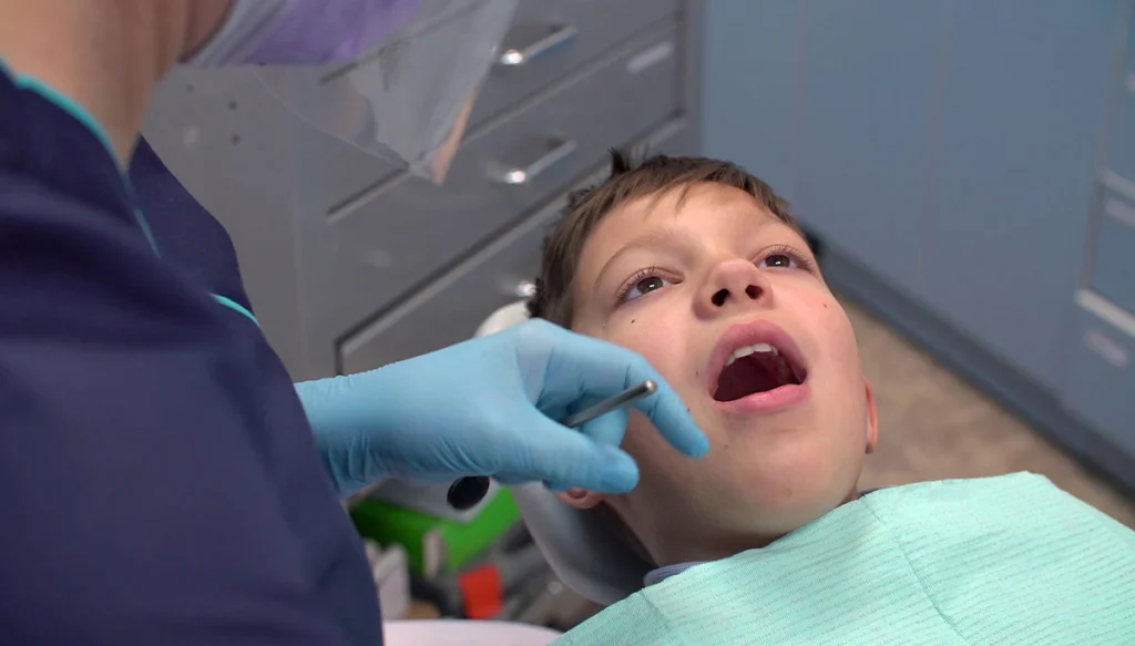 young boy in dentist chair getting mouth examined