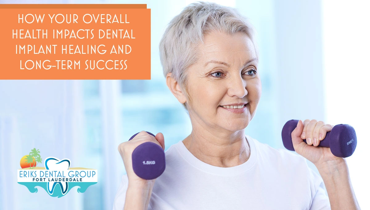older woman smiling while holding up weights in each hand