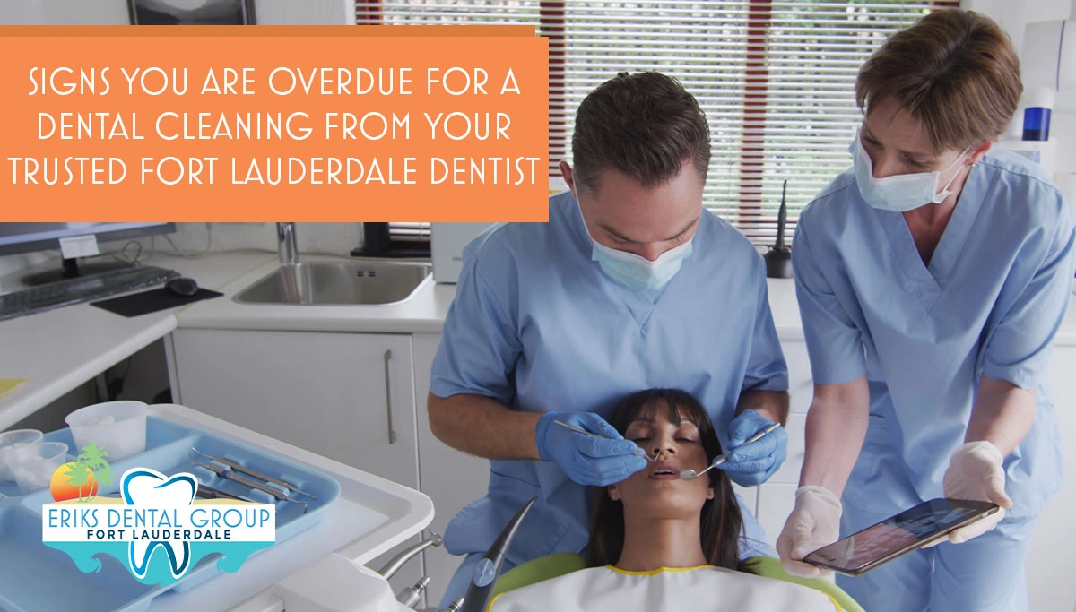 Dentist with assistant cleaning a patient's teeth in a dentists chair