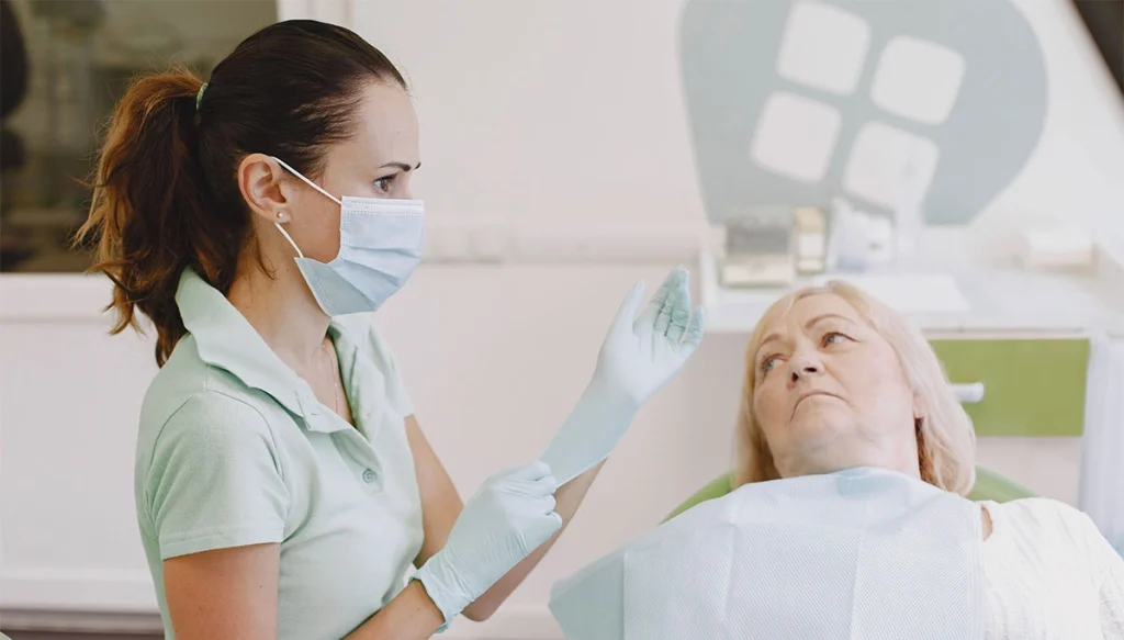 senior patient in dentist chair looking at the dentist